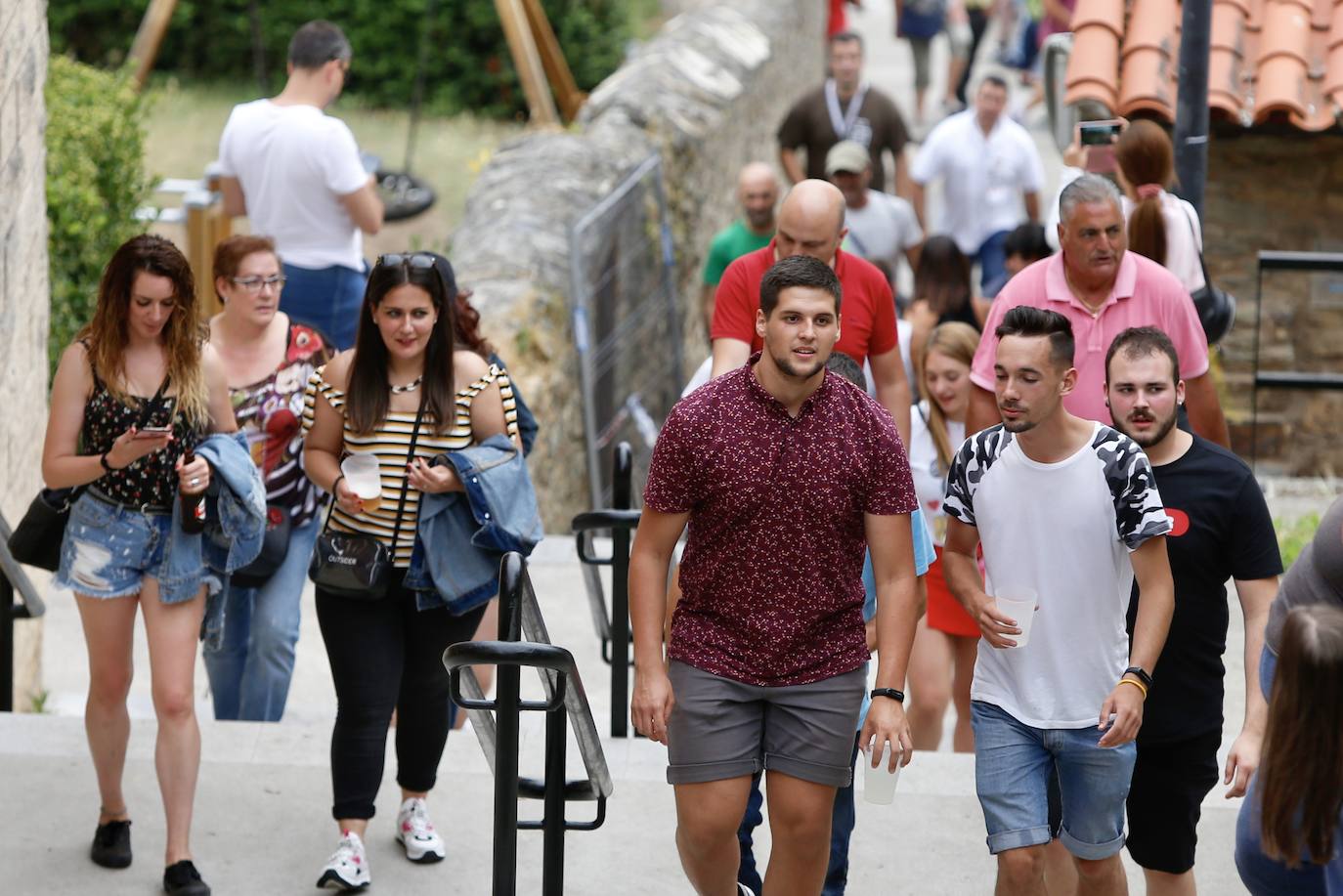 Miles de personas se reparten en los alrededores del Puente Romano y por las calles de la localidad para disfrutar de la tradicional Descarga que cada año hace vibrar a cangueses y visitantes.