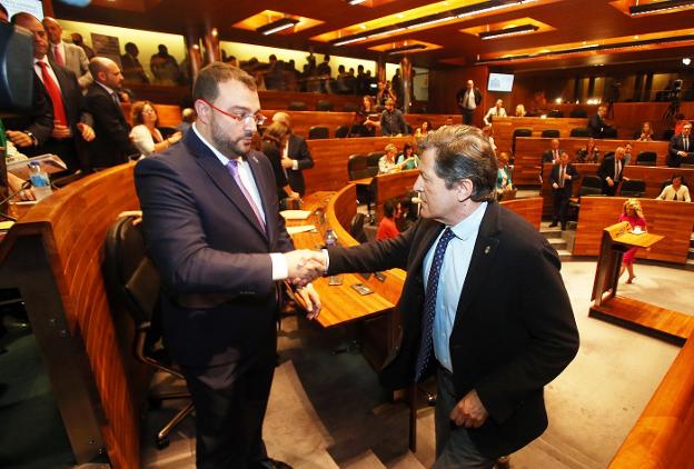 Javier Fernández, presidente saliente, felicita a su sucedor, Adrián Barbón, tras ser investido nuevo jefe del Ejecutivo. 