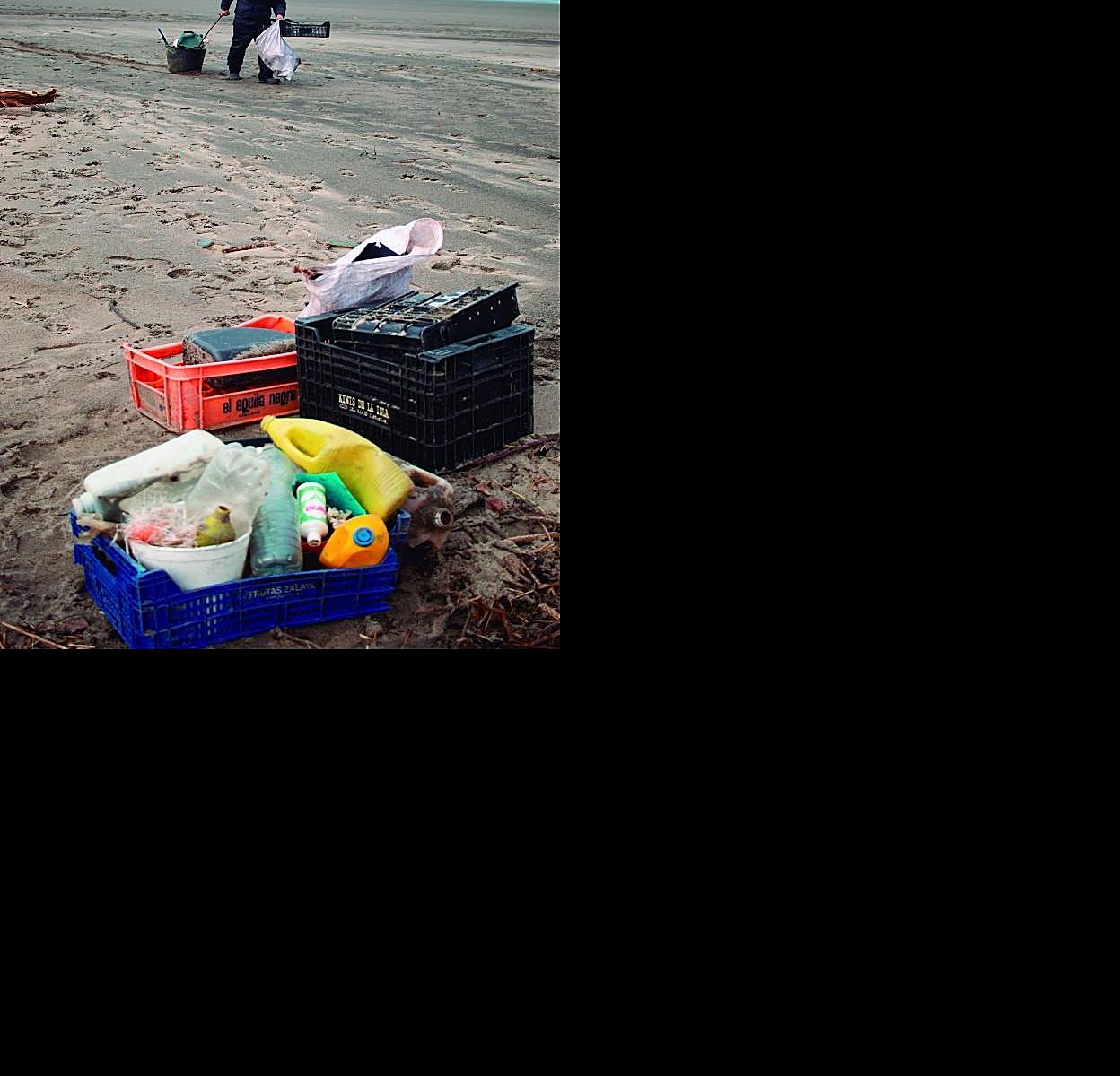Un voluntario recoge basuras en el playón de Bayas, en Castrillón. 