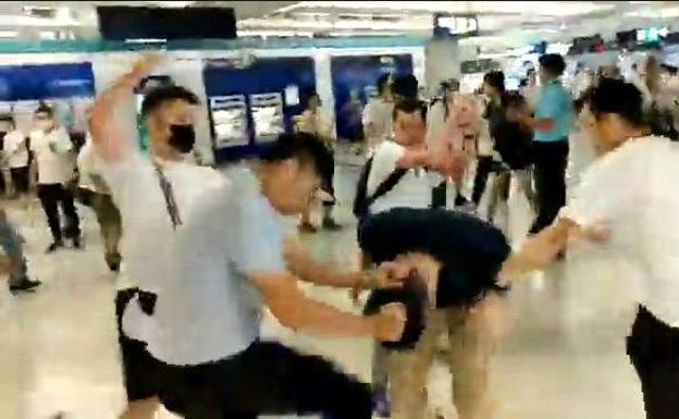Imagen de un vídeo que muestra a los Individuos vestidos de blanco golpean en el metro de Hong Kong a los asistentes a la manifestación.