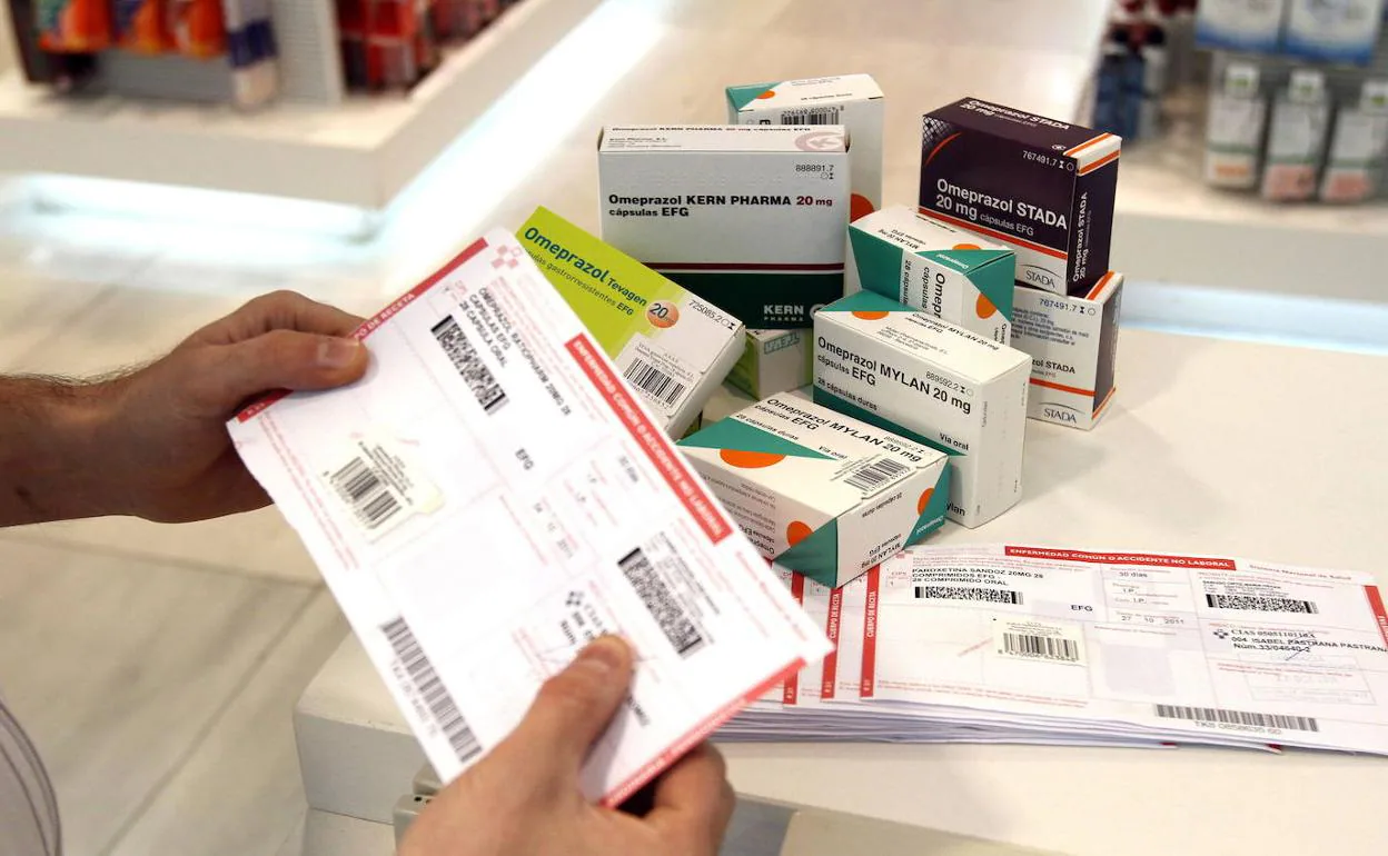 Un farmaceútico con una receta y varias cajas de medicamentos. 