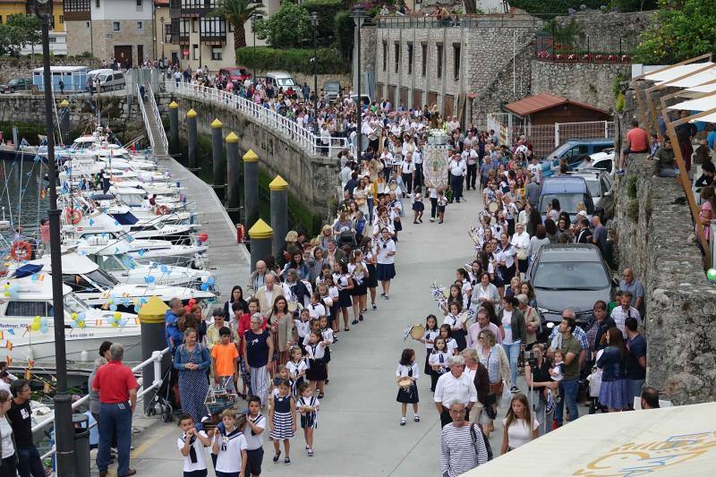 Miles de personas llenan la zona portuaria para ver la procesión. La imagen de la santa embarcó en en el 'Sandra María' y desde la cubierta del barco se lanzó al mar una corona de laurel