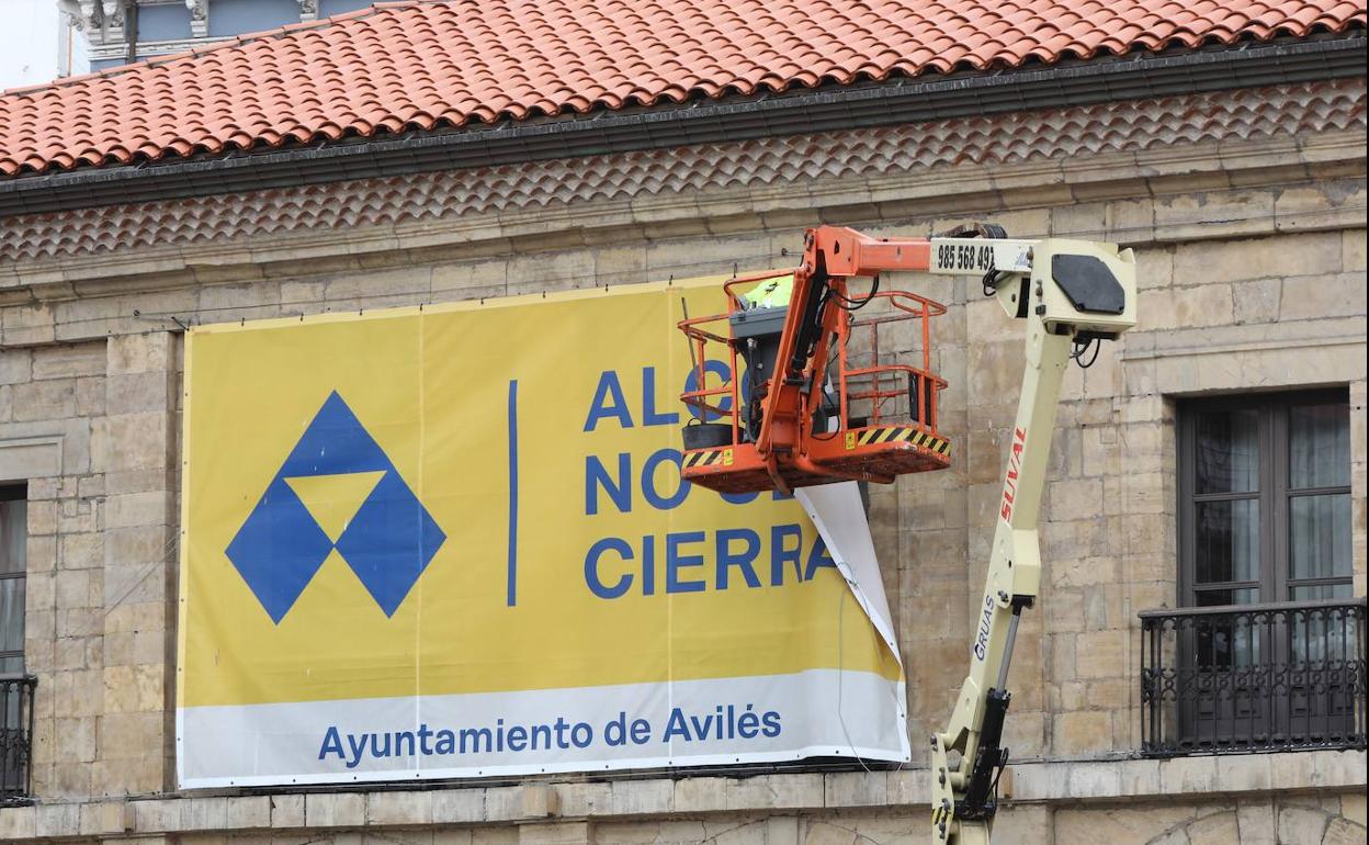 Un operario, retirando una de las pancartas. 