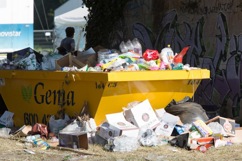 La multitudinaria fiesta del Xiringüelu ha dejado toneladas de basura en el prau Salcéu. Botellas, vasos, y restos de las coloridas casetas que son seña de identidad de la celebración han quedado esparcidos por el campo a la espera de que se retiren, unas labores que ya han comenzado.