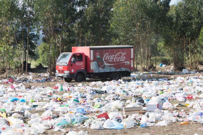 La multitudinaria fiesta del Xiringüelu ha dejado toneladas de basura en el prau Salcéu. Botellas, vasos, y restos de las coloridas casetas que son seña de identidad de la celebración han quedado esparcidos por el campo a la espera de que se retiren, unas labores que ya han comenzado.