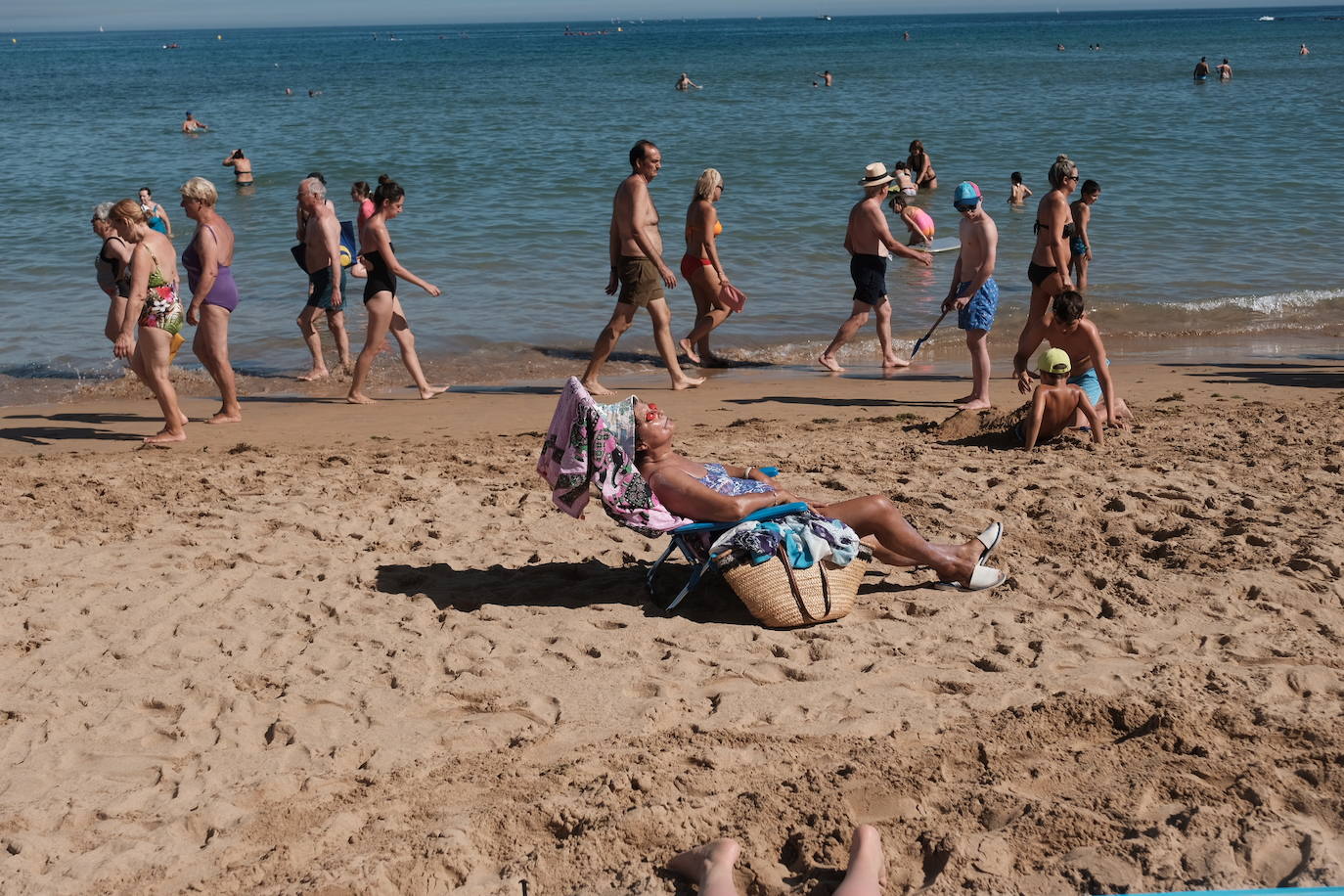 Un baño en la playa para combatir el calor en Gijón