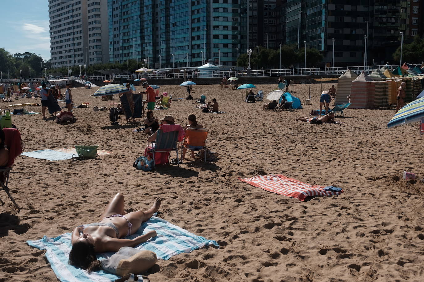 Un baño en la playa para combatir el calor en Gijón