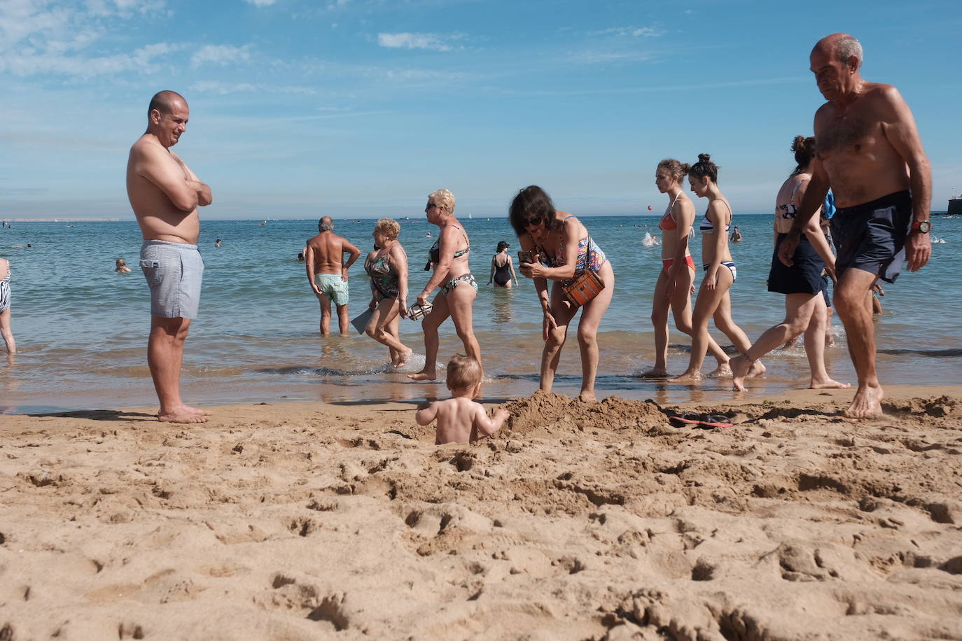 Un baño en la playa para combatir el calor en Gijón