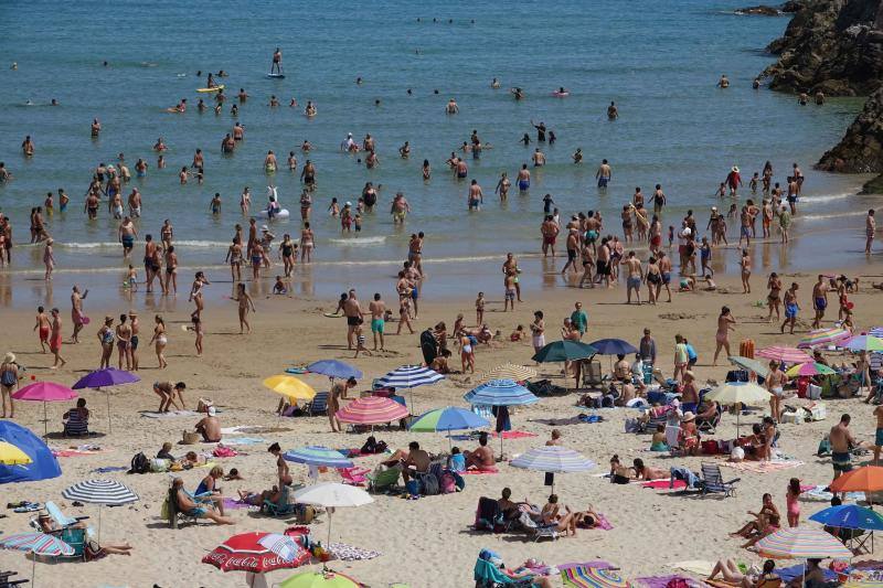 Un baño en la playa para combatir el calor en Gijón