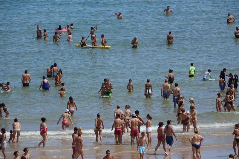 Un baño en la playa para combatir el calor en Gijón