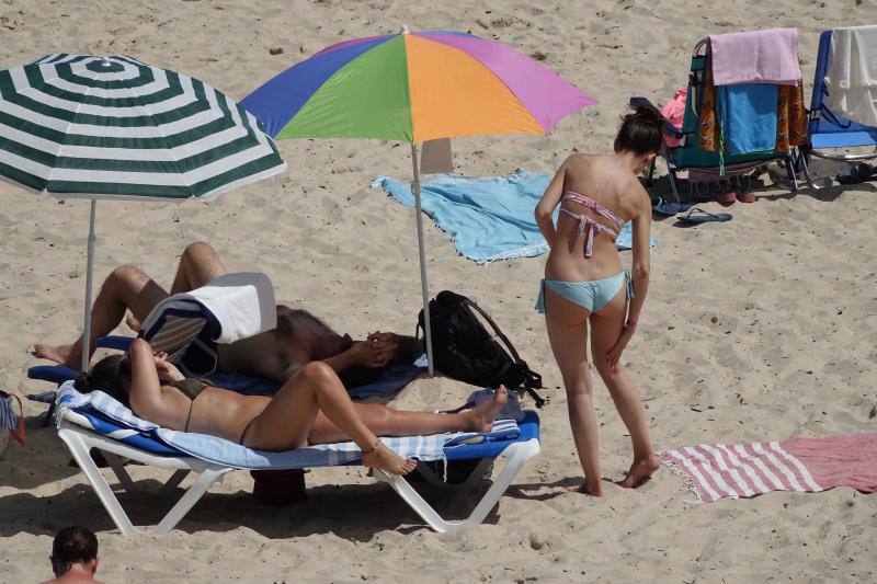 Un baño en la playa para combatir el calor en Gijón