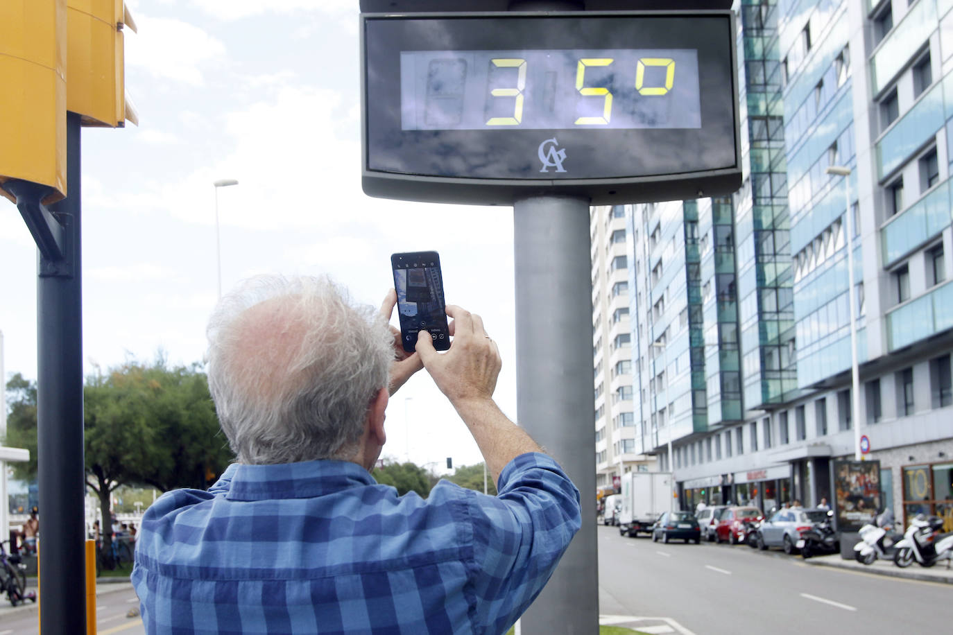 Un baño en la playa para combatir el calor en Gijón