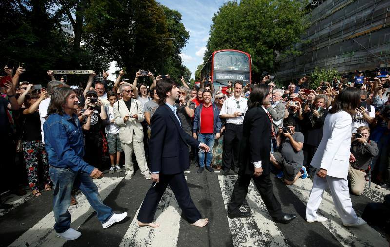No hay duda. La foto de The Beatles cruzando por el paso de peatones de Abbey Road es una de las fotos más famosas de la historia de la música. Esa imagen cumple hoy 50 años y, para celebrarlo, centenares de fans se han congregado en la icónica calle. Incluso un grupo de imitadores del grupo británico llegó a la calle del barrio londinense de St John's Wood en una réplica del psicodélico Rolls Royce de John Lennon. Toda una gran fiesta para para conmemorar la iamgen que inmortalizó el escocés Iain Macmillan a las 11 horas y 35 minutos del 8 de agosto de 1969. En una sesión fotográfica de diez minutos hizo solo seis fotos y la que se convirtió en la imagen del álbum 'Abbey Road' fue la quinta, en la que los cuatro músicos caminan al unísono.