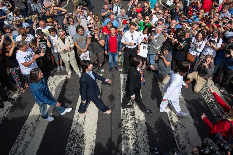 No hay duda. La foto de The Beatles cruzando por el paso de peatones de Abbey Road es una de las fotos más famosas de la historia de la música. Esa imagen cumple hoy 50 años y, para celebrarlo, centenares de fans se han congregado en la icónica calle. Incluso un grupo de imitadores del grupo británico llegó a la calle del barrio londinense de St John's Wood en una réplica del psicodélico Rolls Royce de John Lennon. Toda una gran fiesta para para conmemorar la iamgen que inmortalizó el escocés Iain Macmillan a las 11 horas y 35 minutos del 8 de agosto de 1969. En una sesión fotográfica de diez minutos hizo solo seis fotos y la que se convirtió en la imagen del álbum 'Abbey Road' fue la quinta, en la que los cuatro músicos caminan al unísono.