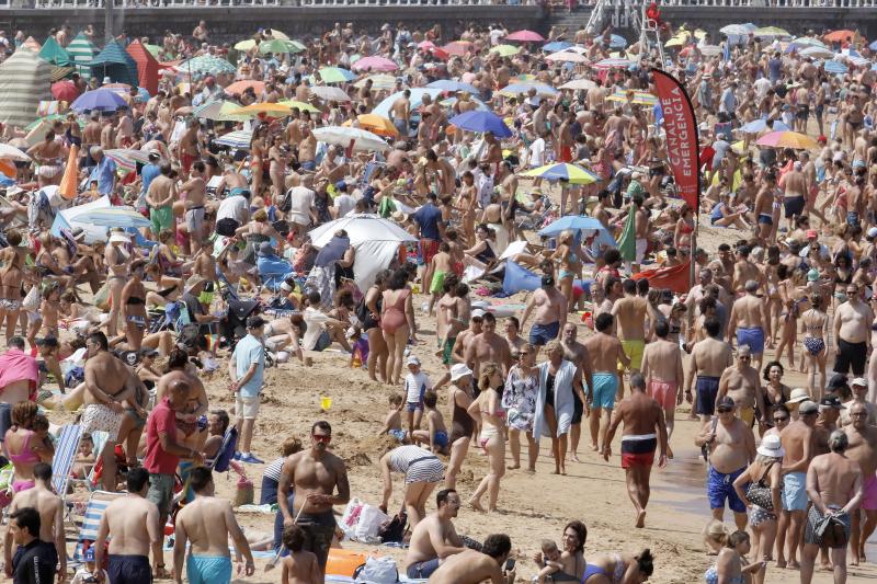 Difícil encontrar sitio en la arena para estirar la toalla. El sol y las altas temperaturas de este sábado han animado a miles de personas a disfrutar de las playas de la región, como muestras las imágenes de San Lorenzo, Salinas y Candás.