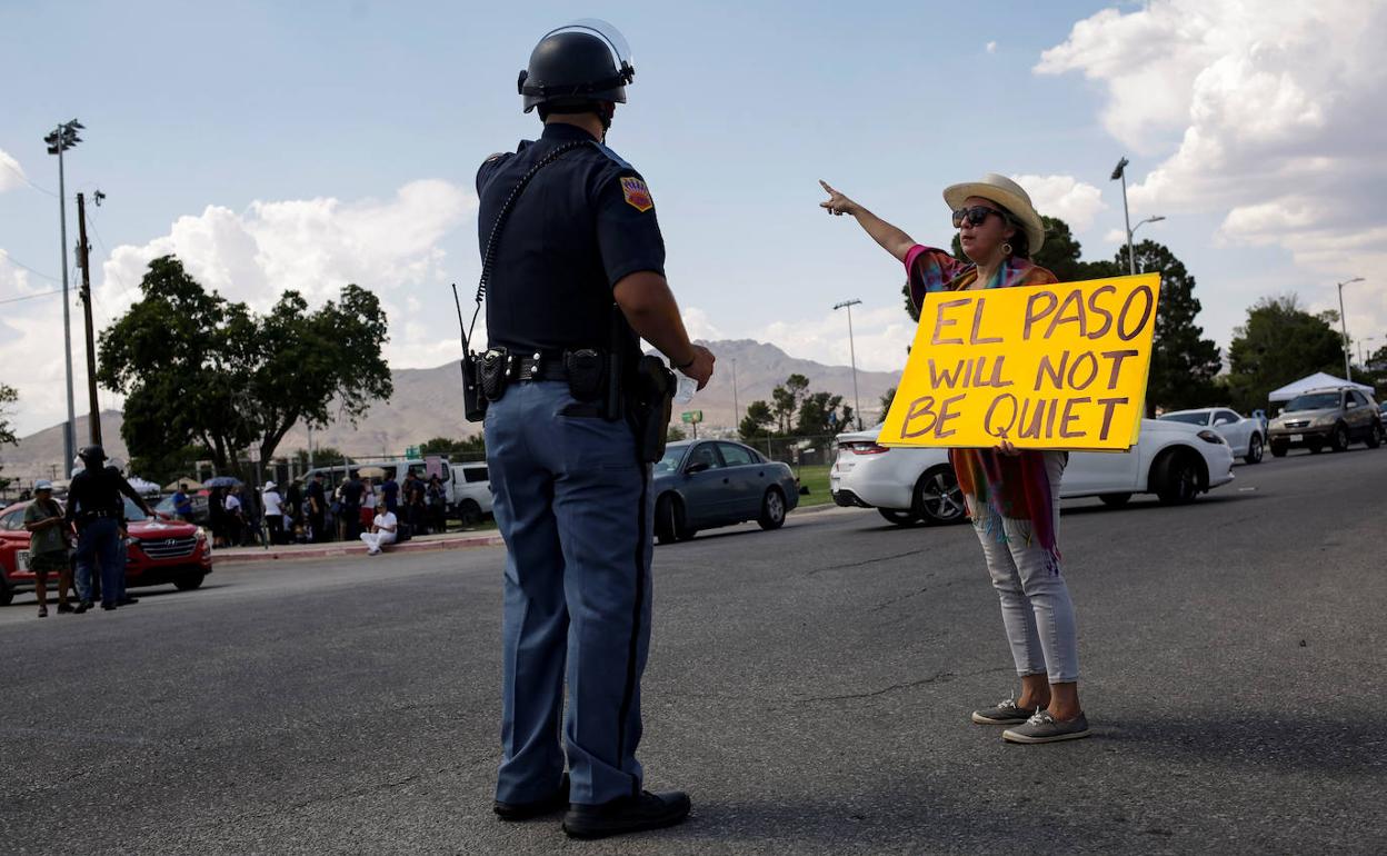 Una mujer muestra un cartel a un policía con la leyenda 'El Paso no callará'.