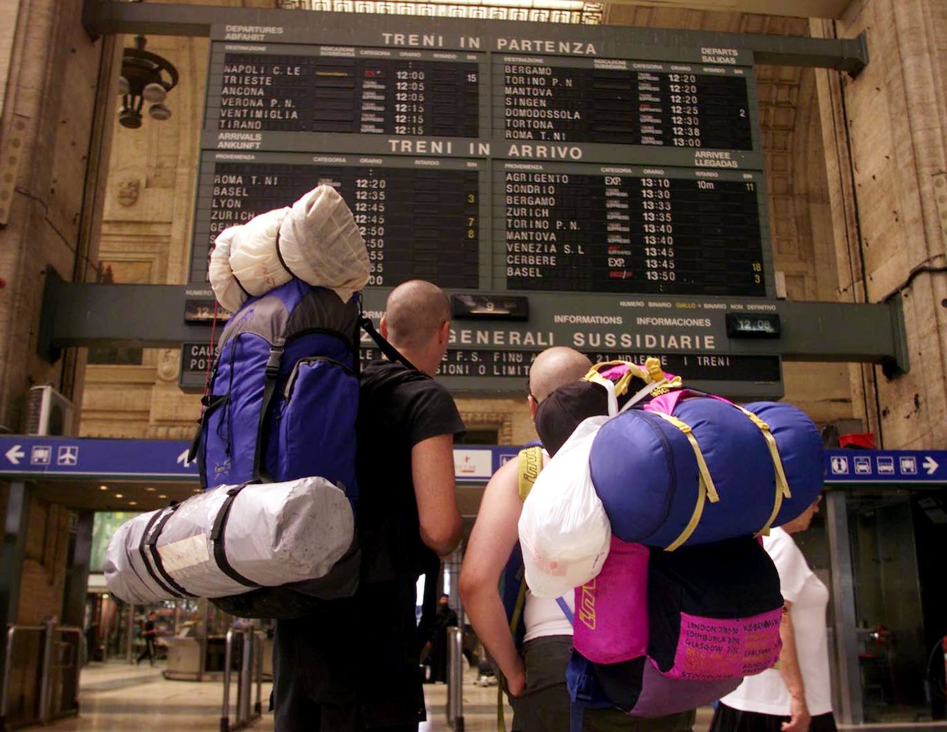 Dos mochileros comprueban los horarios en la estación central de Milán, en Italia 