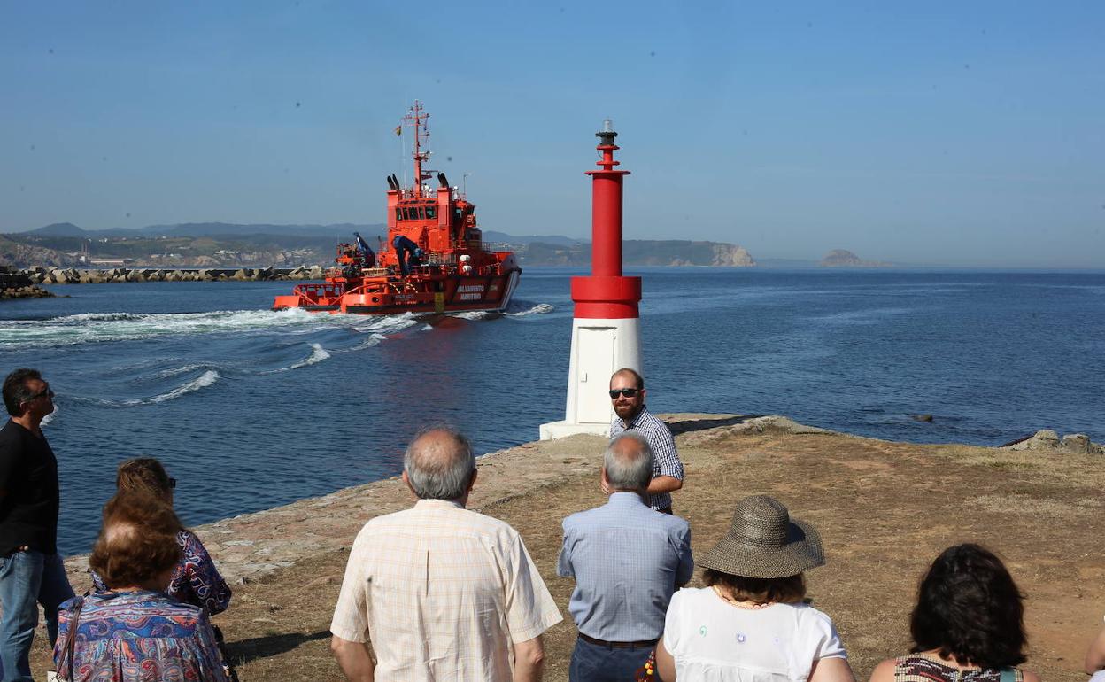 El guía ofrece explicaciones mientras pasa el buque de Salvamento Marítimo 'ramiro de Maeztu' 