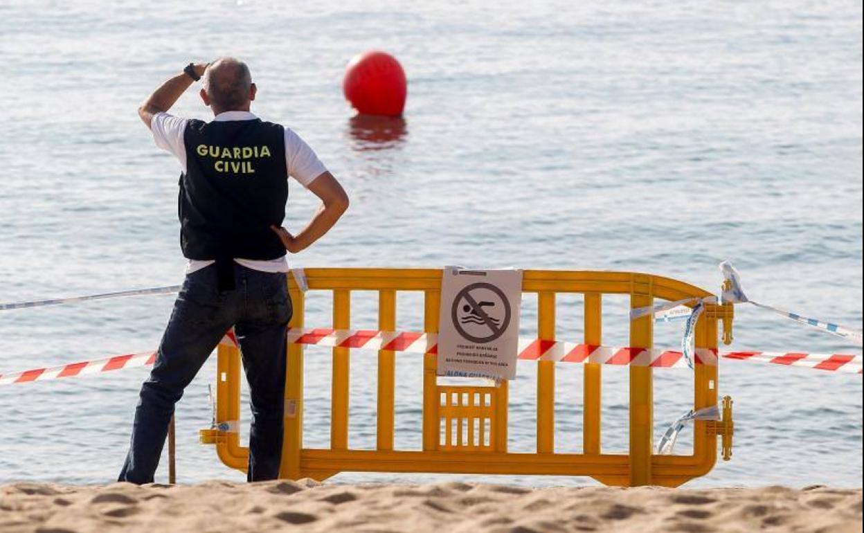 a Guardia Civil controla el perímetro de seguridad en la playa del Cristall de Badalona.