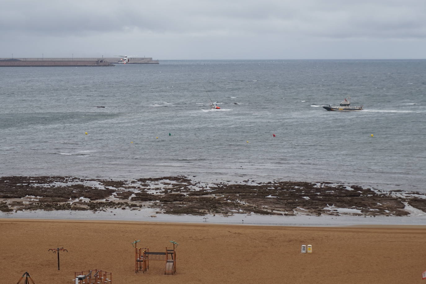 Un velero a la deriva ha obligado a poner en marcha un amplio dispositivo de emergencia en la playa de Poniente. El único tripulante de la embarcación ha sido rescatado con vida por el helicóptero Helimer Cantábrico y trasladado al Hospital de Jove.