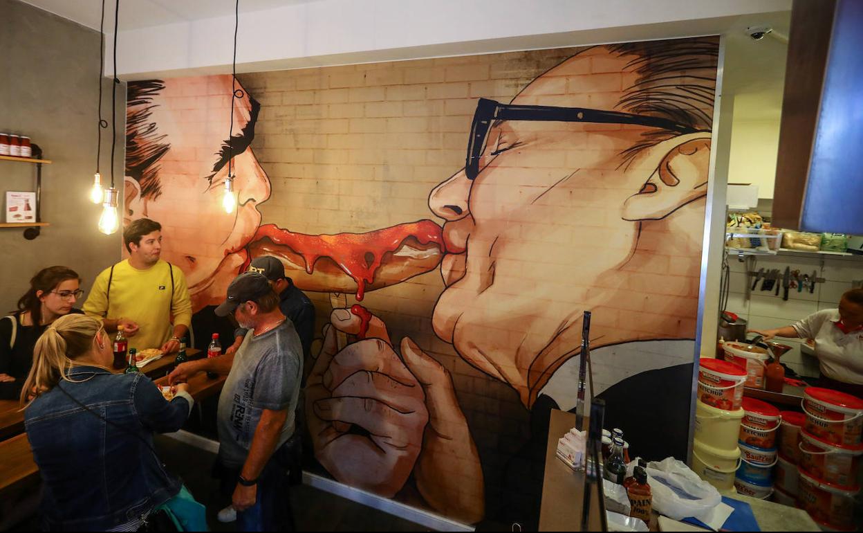 Un mural en un bar de Berlín recrea con una 'currywurst' el beso de Honecker y Brezhnev.