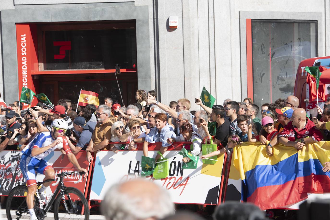 Numerosos aficionados se agolparon en la calle Uría de la capital para ver a los corredores en la etapa 14 entre San Vicente de la Barquera y Oviedo. 
