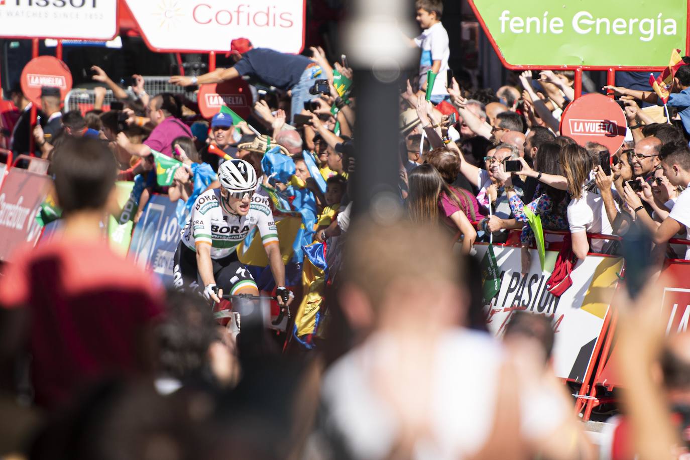 Numerosos aficionados se agolparon en la calle Uría de la capital para ver a los corredores en la etapa 14 entre San Vicente de la Barquera y Oviedo. 