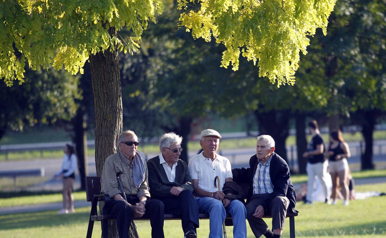 Cuatro hombres descansan en un parque de Oviedo
