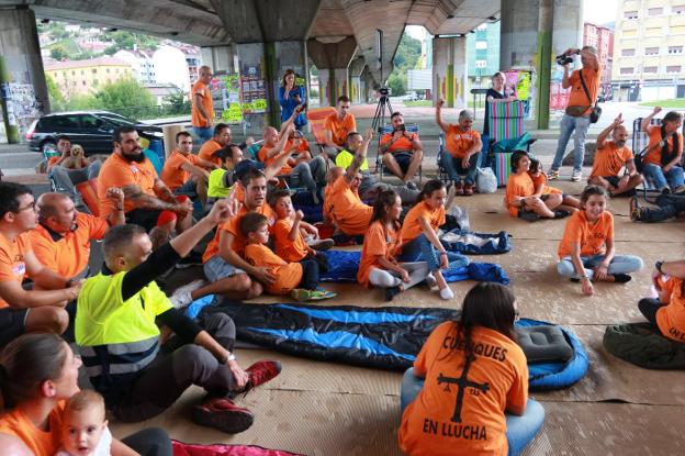 Trabajadores, con sus familias, preparados para pasar la noche bajo el puente que une los distritos de Sama y La Felguera. 