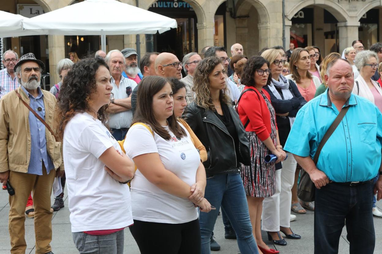 Varias personas escuchan guardan cinco minutos de silencio tras la lectura del manifiesto. 