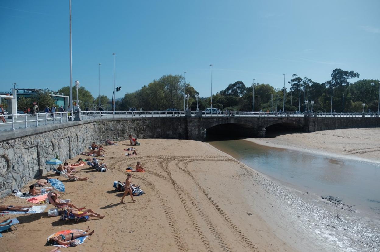 Desembocadura del Piles en la playa de San Lorenzo, en cuyo arenal decenas de personas disfrutaron ayer del buen tiempo. 