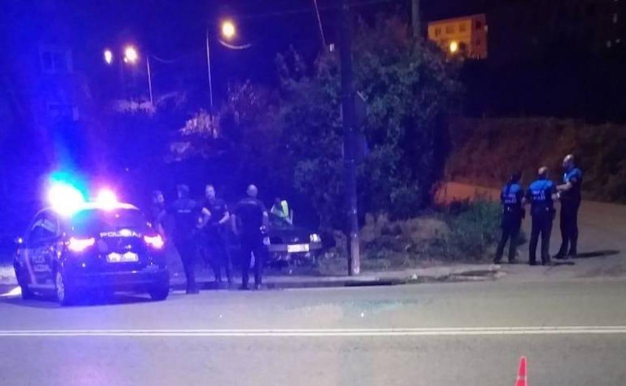 La Policía Nacional y la Local junto al coche siniestrado en el acceso a Bustiello desde la avenida de Gijón. 