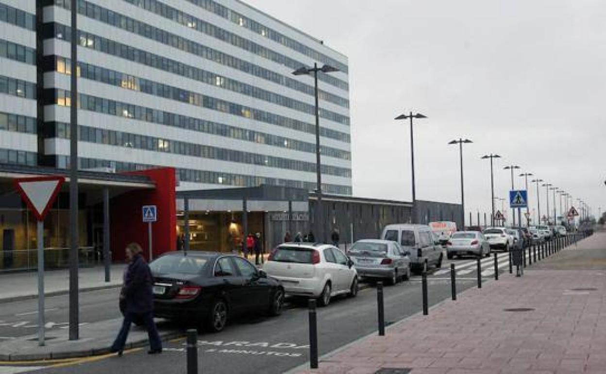 Imagen de la entrada de hospitalización del HUCA con varios coches aparcados.