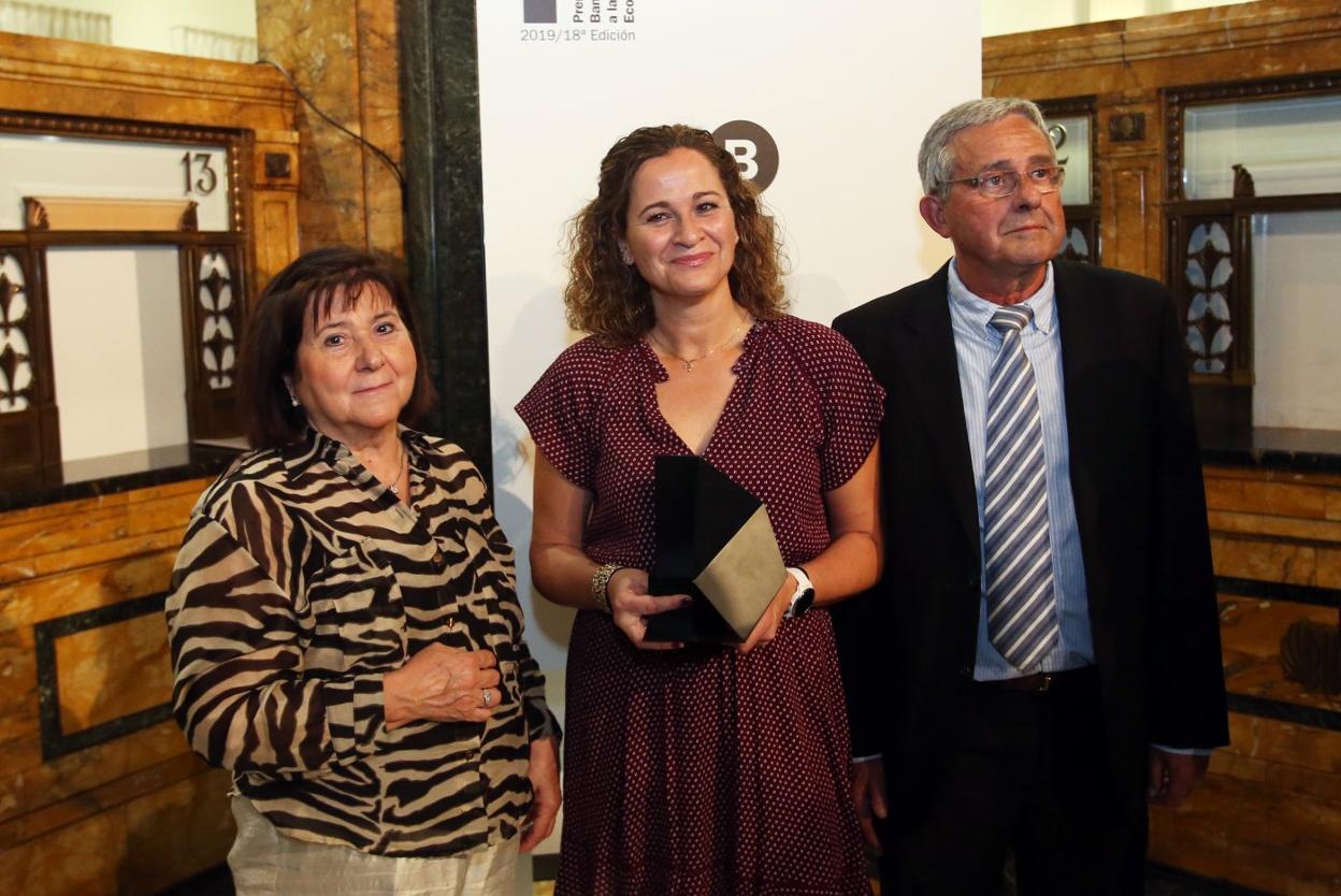 La premiada, Irma Clots, junto a sus padres, sostiene el premio. 