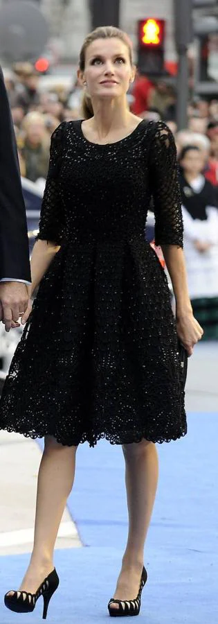 Un antes y un después fue lo que consiguió este look con el que Letizia apareció en la ceremonia de los premios en 2010. Sin duda uno de sus looks más aplaudidos hasta el momento que estaba compuesto por un vestido negro de raso, con manga francesa y falda de vuelo estilo años 50. Todo rematado con detalles de azabache bordados y una sencilla coleta alta.