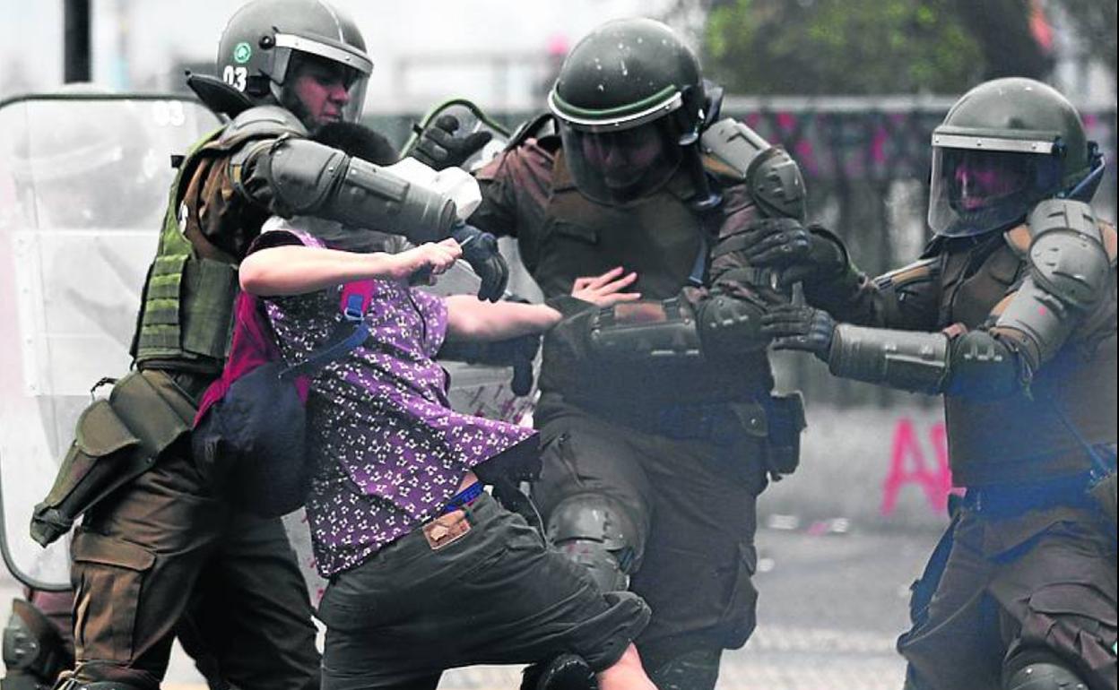 Antidisturbios detienen a un manifestante en Santiago.