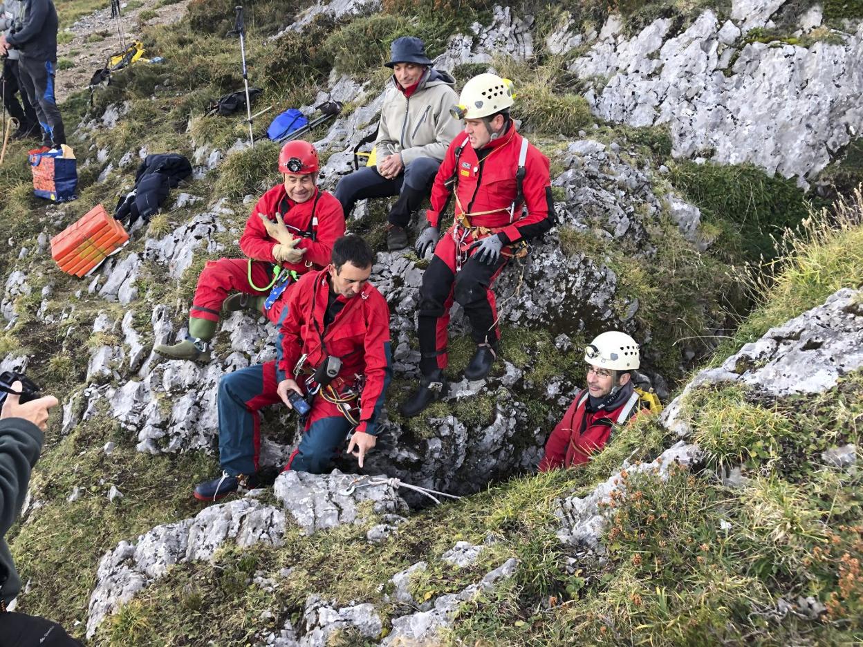 Uno de los voluntarios de la Agrupación de Espeleología Ramaliega sale de la sima en presencia de otros compañeros. 