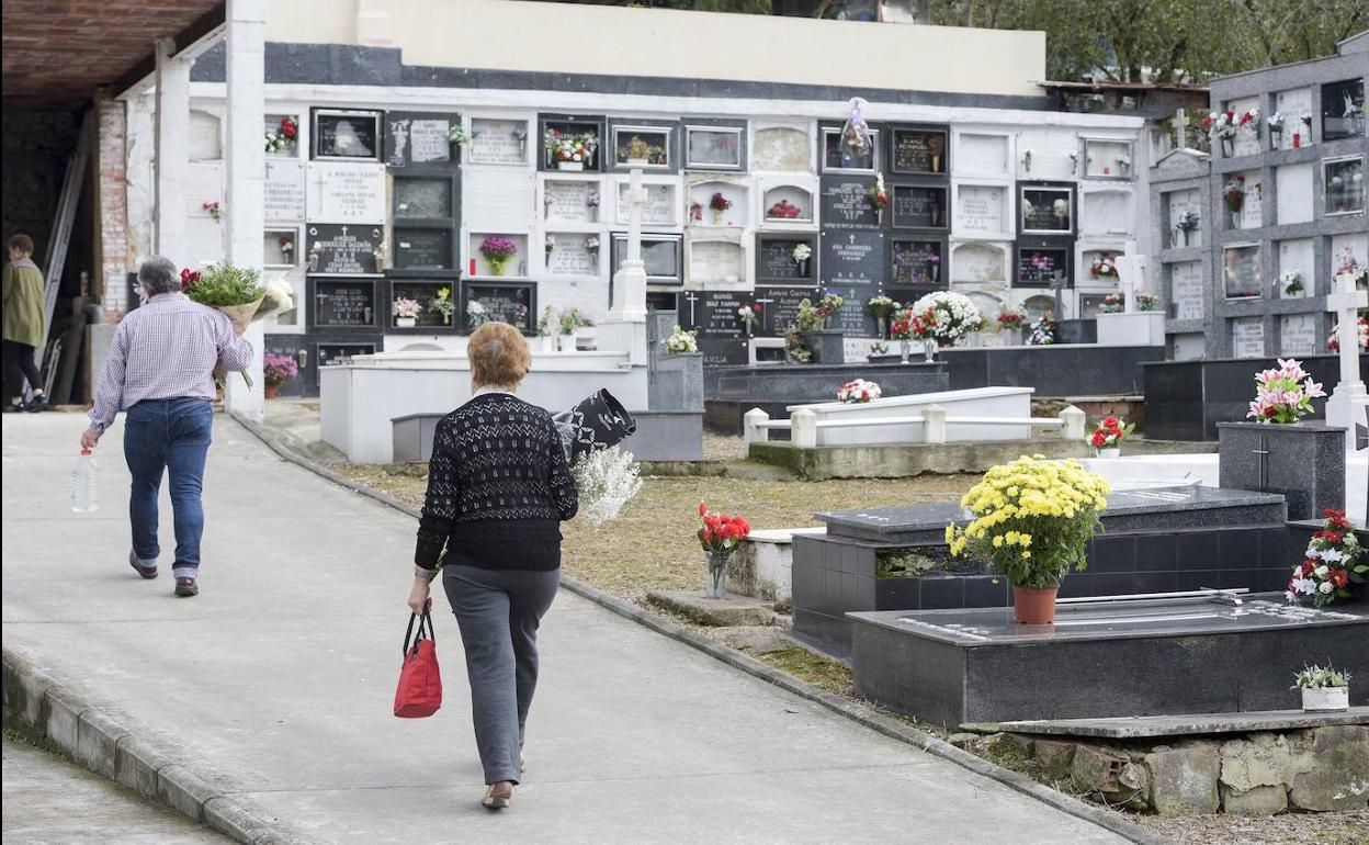 Varias personas visitan un cementerio durante el puente de Todos los Santos. 