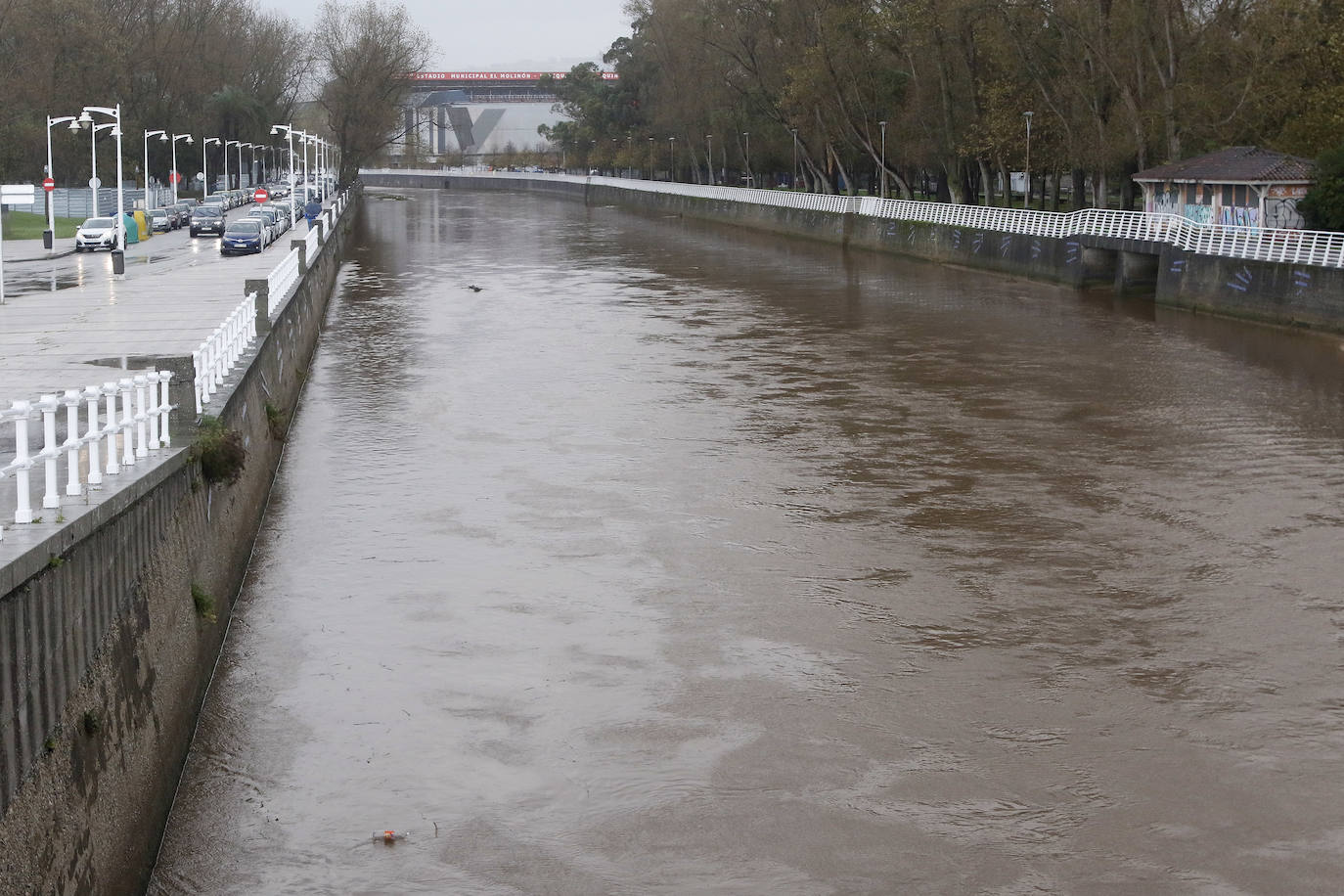 El temporal que azota Asturias ha ocasionado que la bahía de San Lorenzo apareciera este viernes con agua de color marrón, procedente del río Piles y del arrastre de las aguas de escorrentía, lo que se unió a una mar muy revuelta
