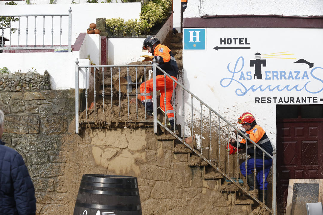 Los operarios han tenido que dedicarse a fondo tras el argayu de Tazones que ha obligado a desalojar dos establecimientos hosteleros y una vivienda y amenaza a otros edificios. 