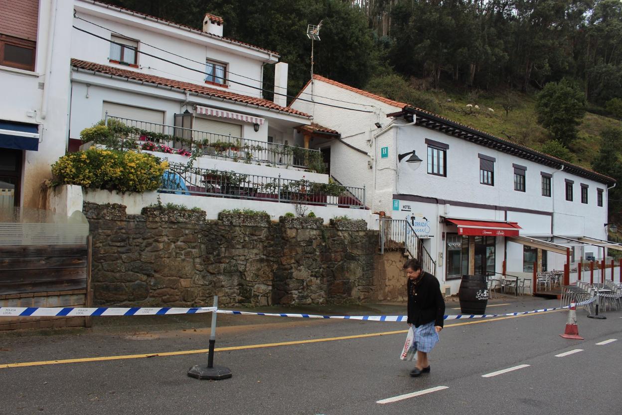 Una vecina pasa junto a las viviendas afectadas por el argayo, que siguen acordonadas. 