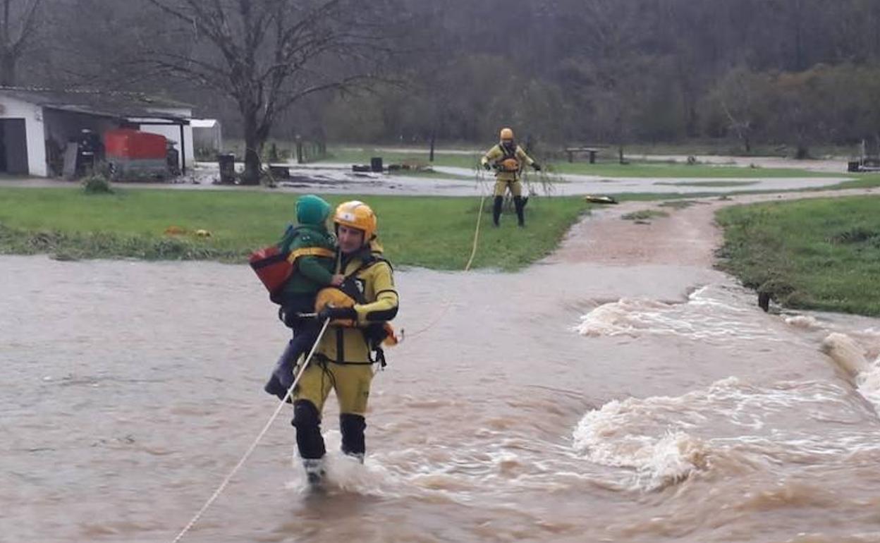 Efectivos de Bomberos rescatan a una familia en Piloña ante el desbordamiento del río.