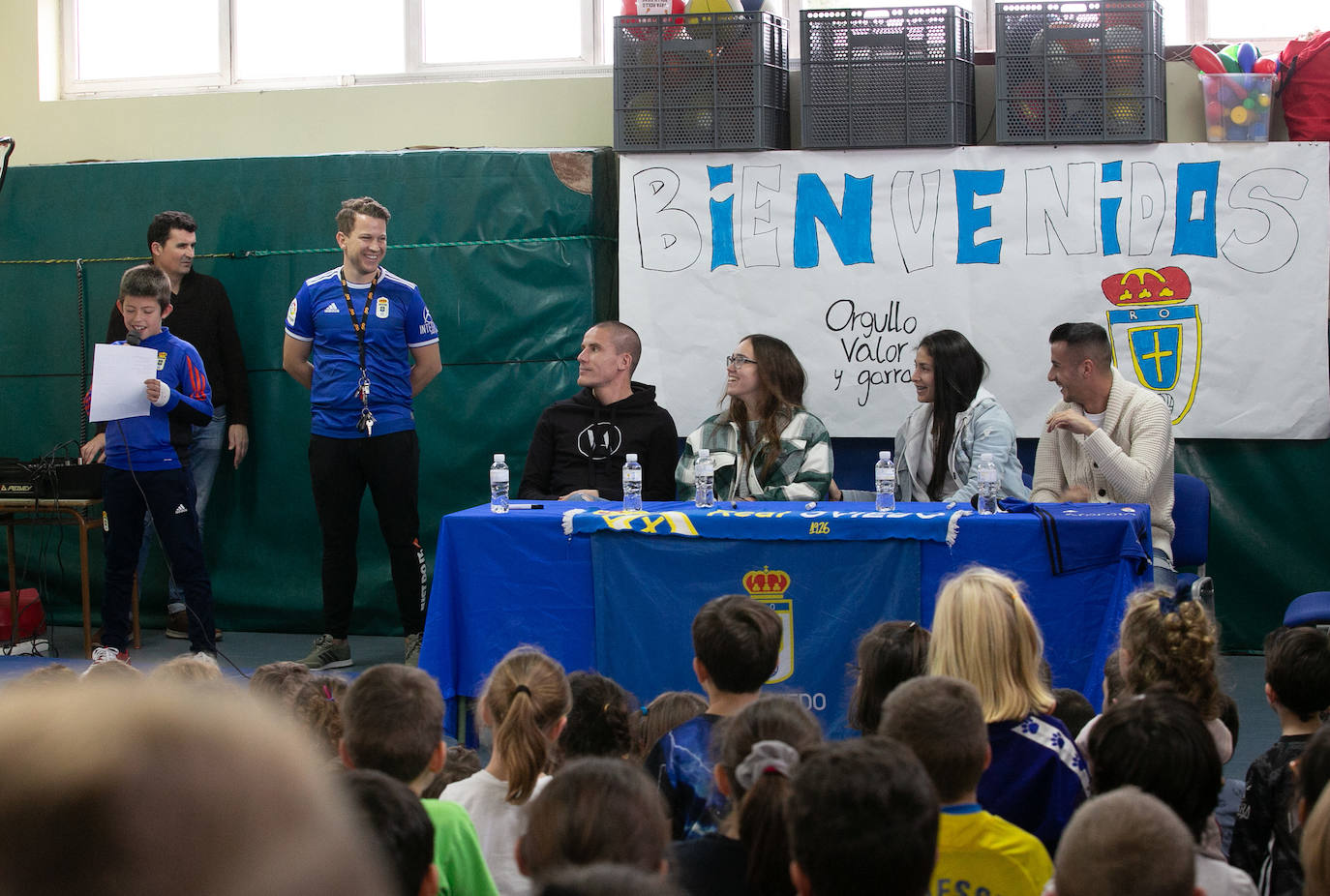 Los alumnos y alumnas del CP El Carbayu (Lugones) llenaron una de sus aulas ataviados de camisetas y bufandas del Real Oviedo para recibir a sus ídolos del primer equipo, los mediocentros Lolo y Sergio Tejera, y a las referentes del femenino, Henar Muiña y Gloria Villamayor. Los aficionados más jóvenes arrancaron las sonrisas y confidencias de los futbolistas en una semana que no ha sido buena para ninguno de los dos equipos. 