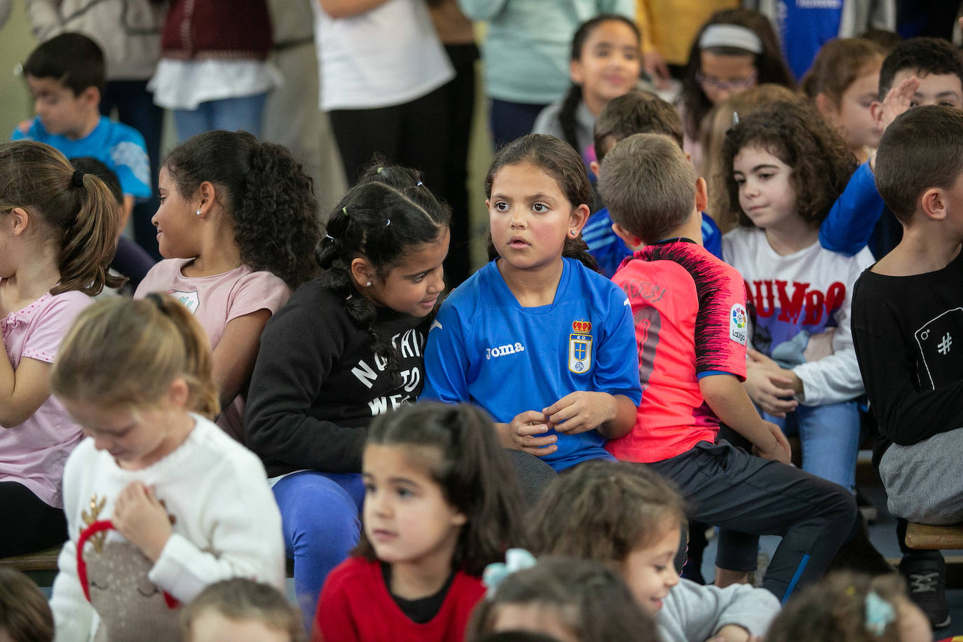 Los alumnos y alumnas del CP El Carbayu (Lugones) llenaron una de sus aulas ataviados de camisetas y bufandas del Real Oviedo para recibir a sus ídolos del primer equipo, los mediocentros Lolo y Sergio Tejera, y a las referentes del femenino, Henar Muiña y Gloria Villamayor. Los aficionados más jóvenes arrancaron las sonrisas y confidencias de los futbolistas en una semana que no ha sido buena para ninguno de los dos equipos. 