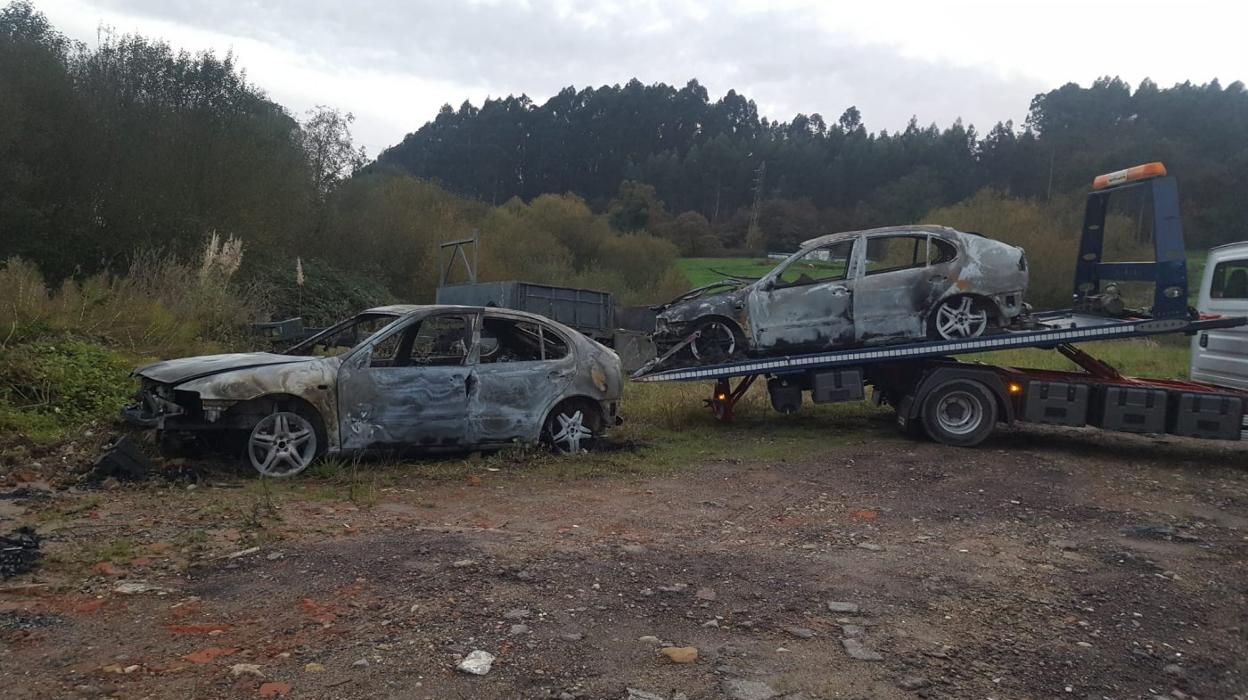 Una grúa retira los dos vehículos calcinados en el Alto de la Miranda, en el concejo de Llanera. 