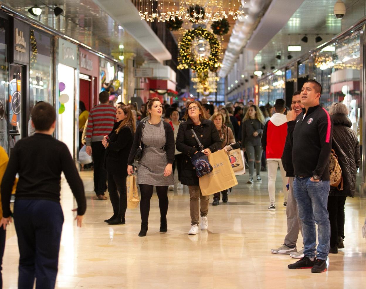 Uno de los pasillos principales de Intu Asturias, repleto de compradores ayer por la tarde. 