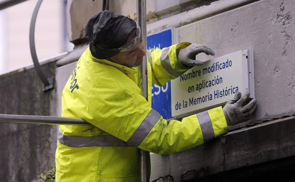 Un operario cambia la placa de una de las calles de la ciudad. 