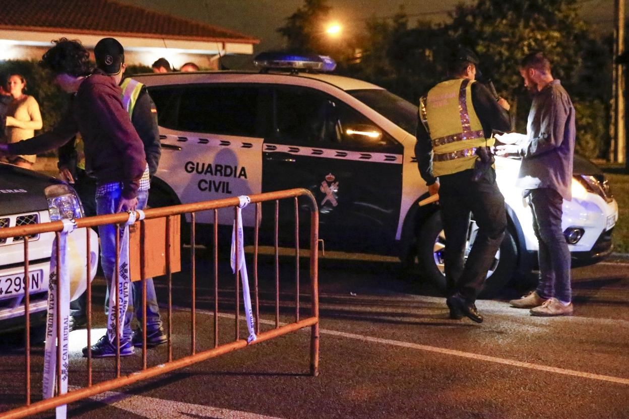 Control policial junto a una de las vallas colocadas en los accesos a la fiestas de Castiello en 2017. 