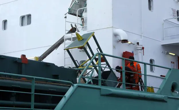 Dos de los tripulantes del barco, trabajan en El Musel en la reparación de los daños. 