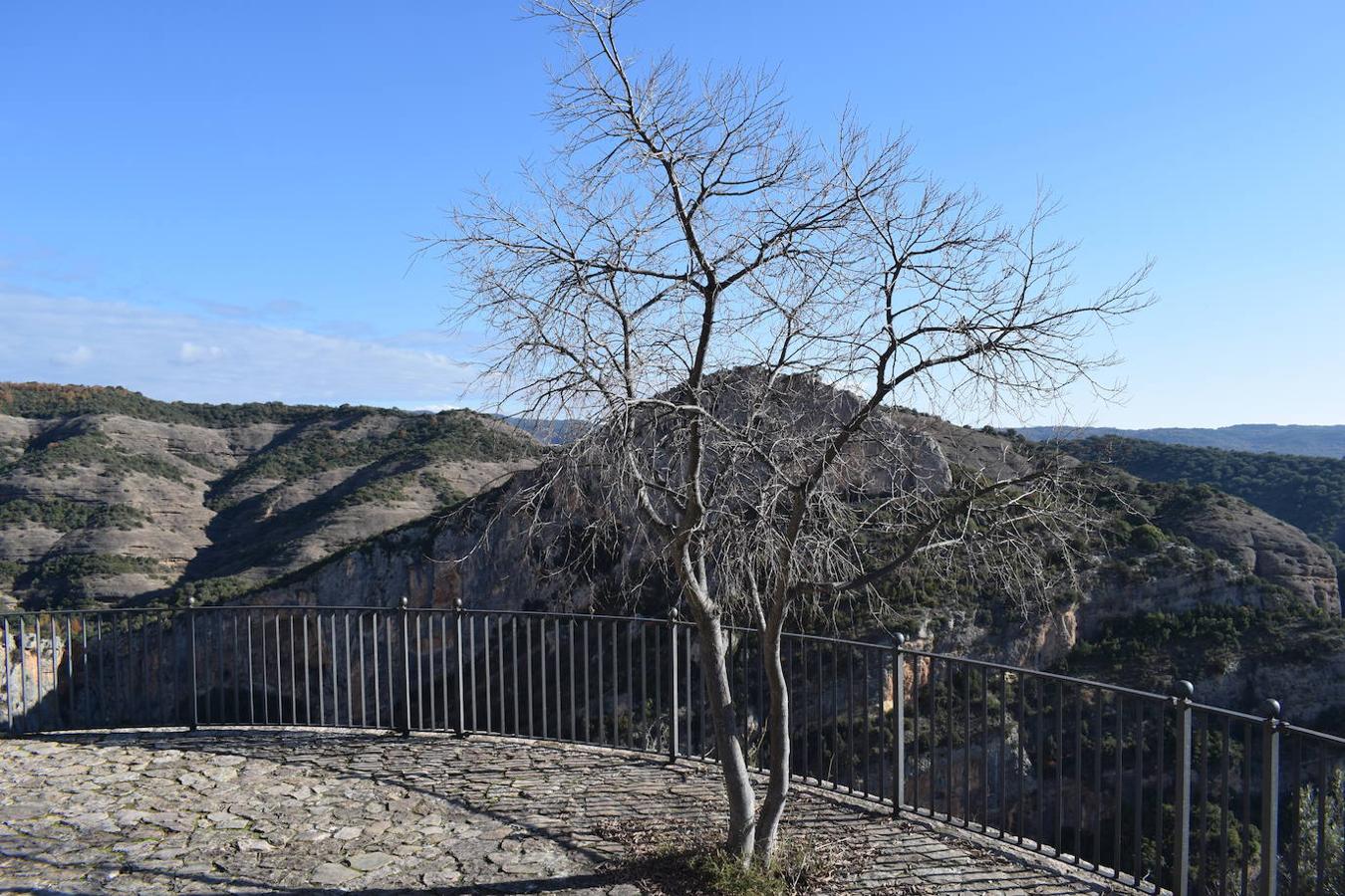 Alquezar se encuentra situado a orillas del río Vero, en el centro de la provincia de Huesca y en la comarca del Somontano de Barbastro. La belleza de su paisaje ha sido una de las principales razones por las que esta villa medieval fue declarada en 1990, Parque Natural de la Sierra y los Cañones de Guara. Hoy en día, este municipio se ha convertido en uno de los destinos turísticos más concurridos de la Sierra de Guara y no solo por el gran legado cultural y artístico que esconde, sino también por la gran cantidad de rutas, barrancos perfectos para los deportes de aventura y paredes perfectas para la práctica de la escalada que este paisaje integra. Un lugar que en otoño se vuelve aún más mágico y del que podrás disfrutar en estas fotografías. 